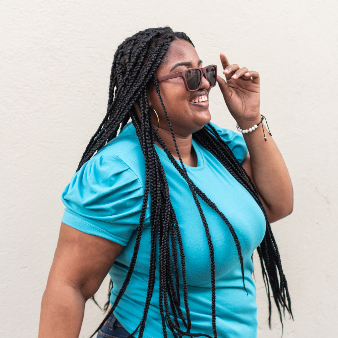 A young black woman in sunglasses smiling