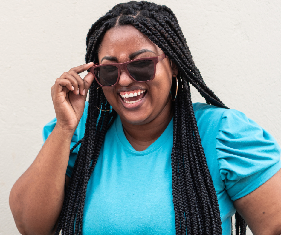 A young black women smiling with sunglasses